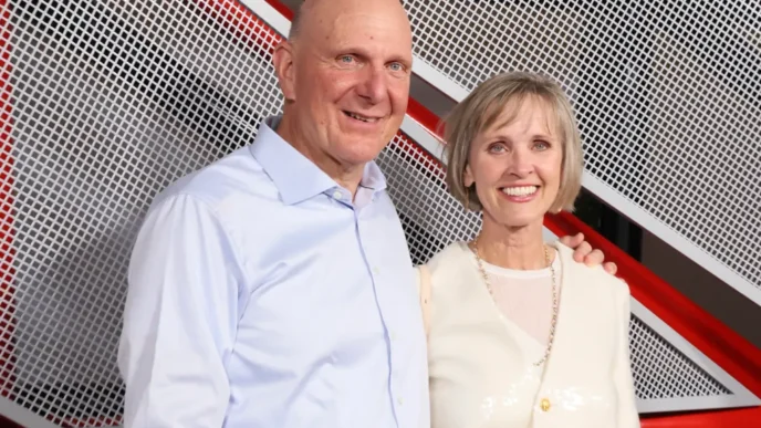 Smiling couple posing together against a white and red metal grid background.