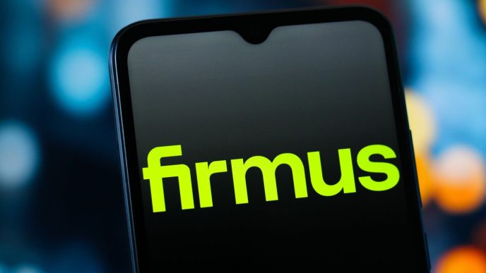 Close-up of a smartphone screen displaying the bright lime-green word 'firmus' on a dark background.