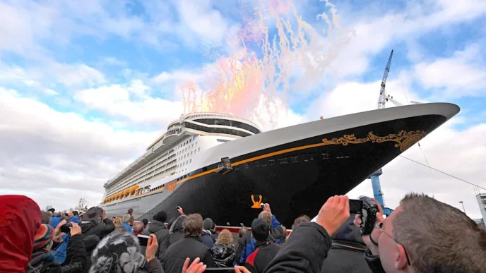 Crowd gathers as a large cruise ship debuts with fireworks above the bow.