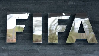 Large reflective metal letters spelling 'FIEA' mounted on a dark stone wall.