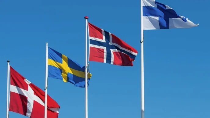 Several Nordic flags (Denmark, Sweden, Norway, Finland) waving against a blue sky e849a