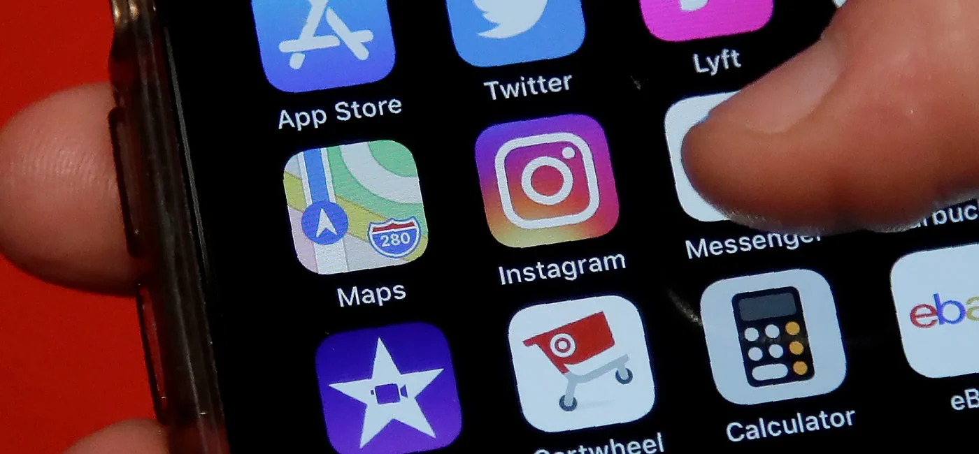 Close-up of a smartphone home screen showing app icons: App Store, Twitter, Lyft, Maps, and Instagram, with a finger near the right edge.