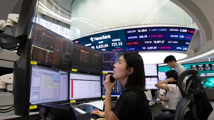Trader at a multi-monitor trading desk monitoring charts and data in a bank’s trading floor.